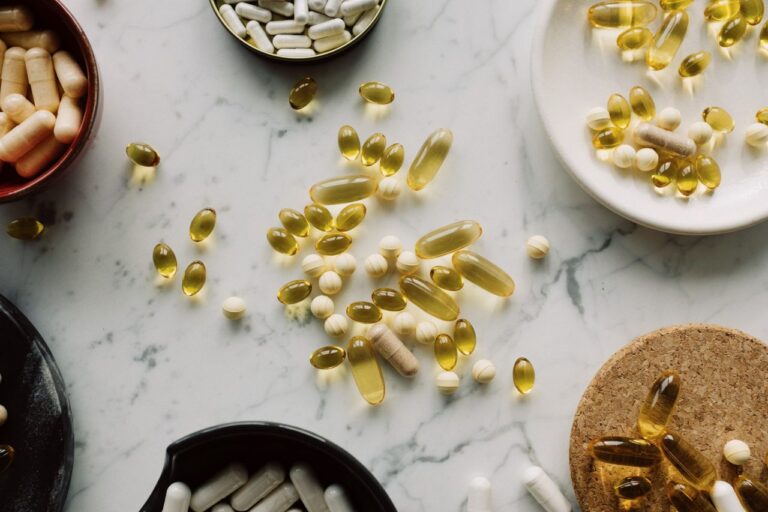 A top view of assorted capsules and pills displayed on a marble surface, showcasing a variety of medicines.