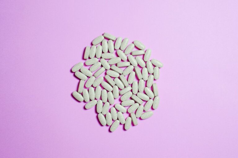 A cluster of white pills on a purple surface, highlighting pharmaceutical themes.